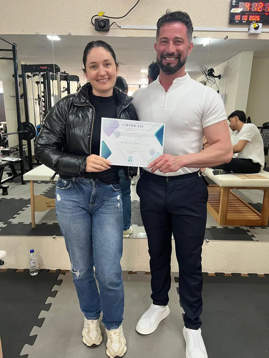 Aluna recebendo certificado ao lado do Prof. Luiz